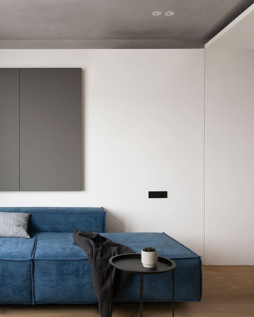 A Minimalist Interior Design With A Blue Sofa And A Side Table