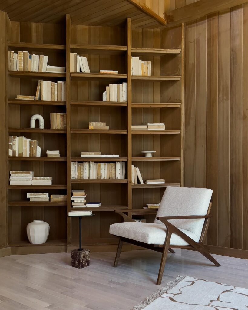 A Cozy Reading Nook with Wooden Shelves and a Comfortable Armchair