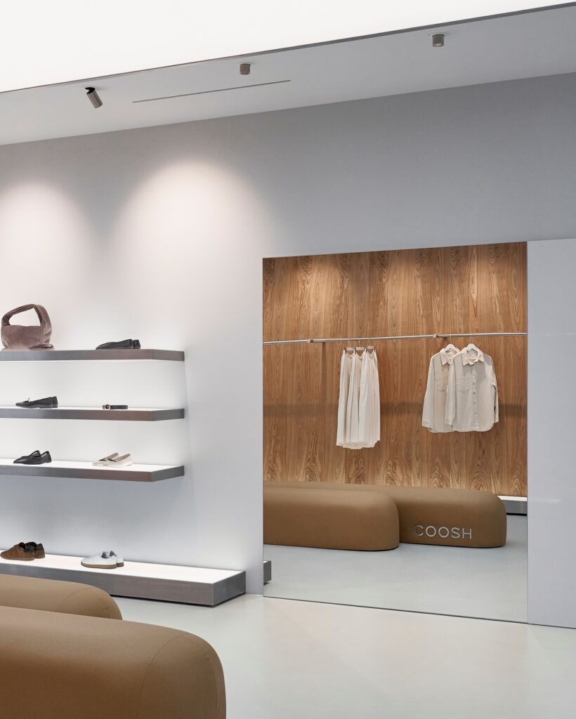 Minimalist Interior Design with Wooden Accent Wall, Shelves, and Hanging Clothing