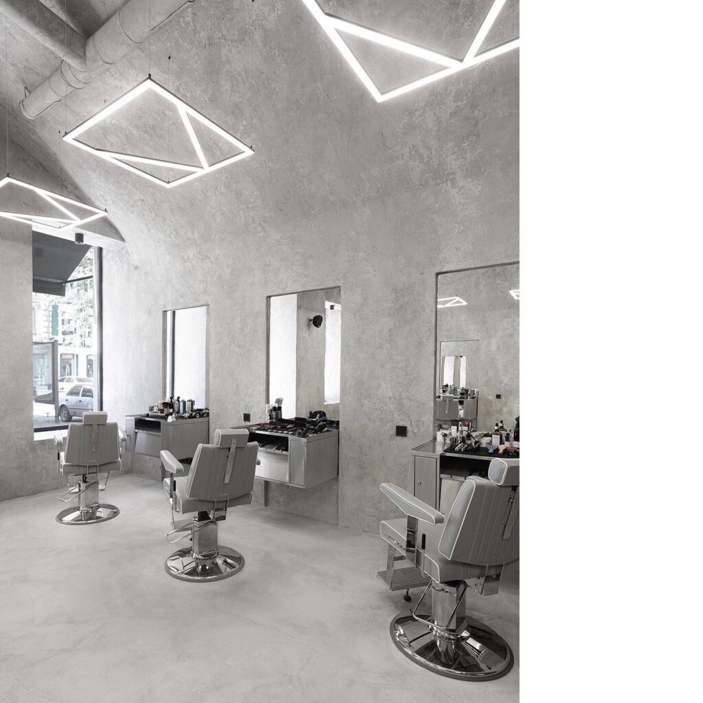 A Modern And Minimalist Hair Salon Interior With Geometric Lighting Fixtures And Concrete Walls