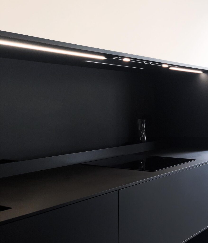 Modern Black Kitchen Counter with Built-in Lighting and Glass Vase