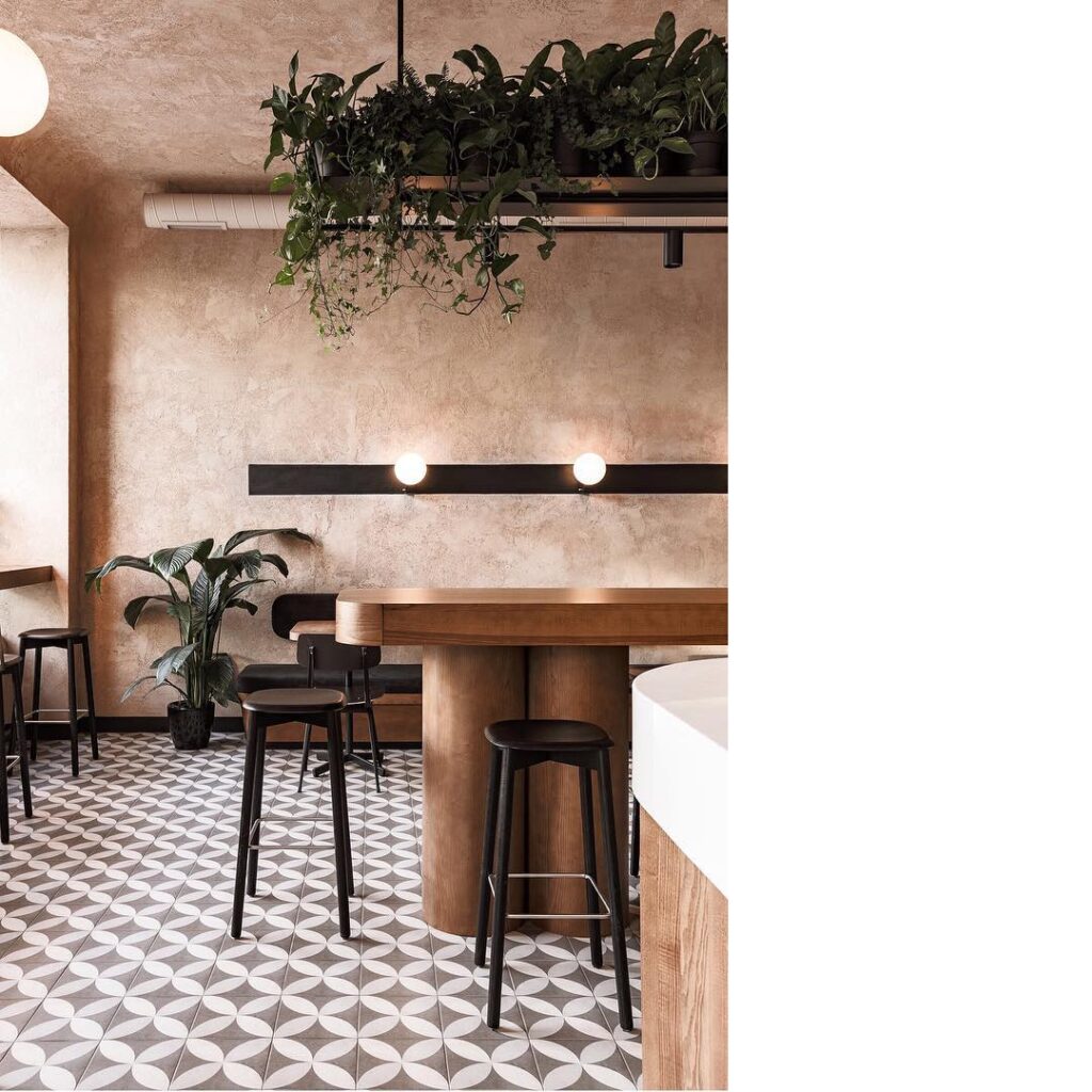 A Modern Interior Design With Wooden Furniture And Lush Greenery