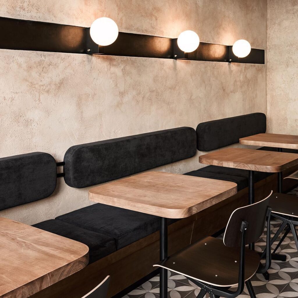 A Modern Interior Design with Wooden Tables and Black Seating