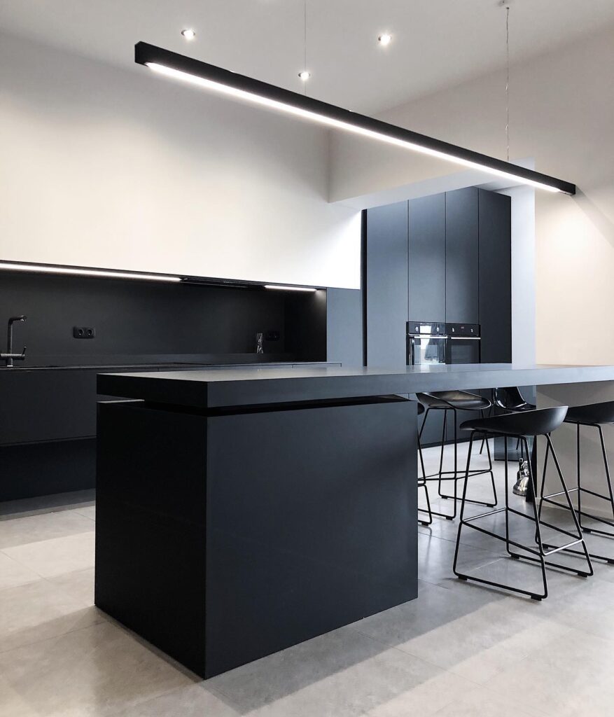 Modern Kitchen Interior With Black Cabinetry, Sleek Appliances, And Minimalist Lighting Fixtures