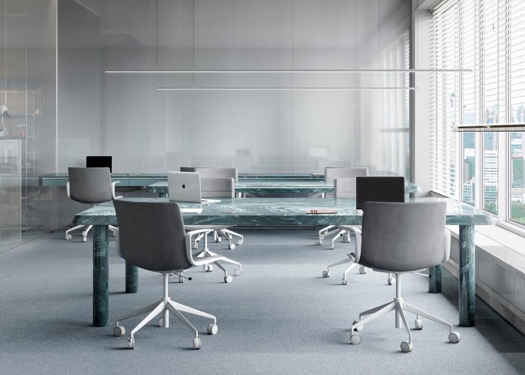 A modern office space with glass desks and chairs designed by Sivak+Partners.