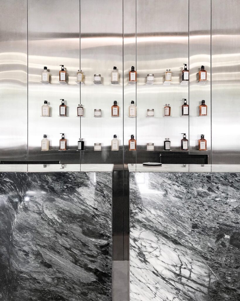 Shelves Displaying Various Fragrance Bottles in a Minimalist Interior Design Setting