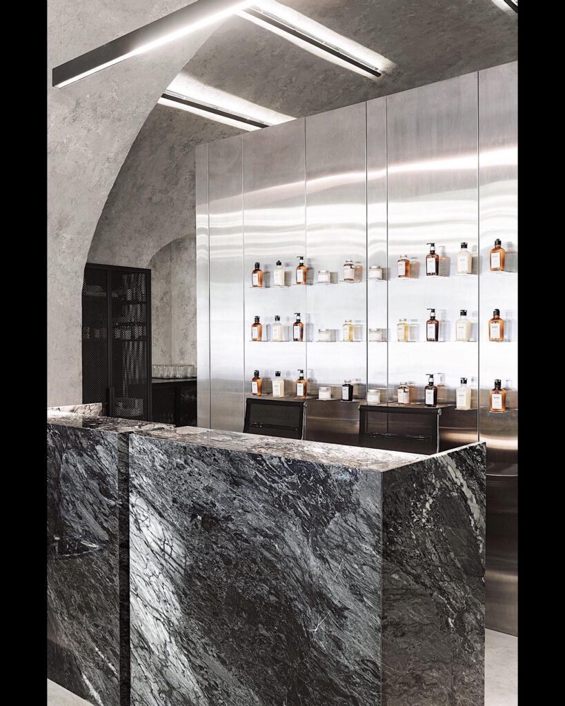 Sleek and Modern Interior Design with Marble Countertops and Shelves of Cosmetic Products