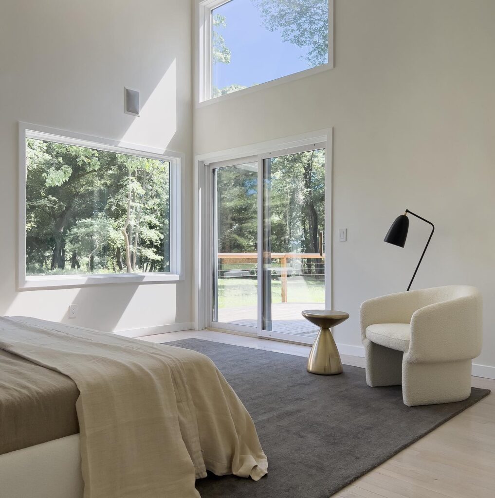 Spacious Bedroom With Large Windows Overlooking Lush Greenery