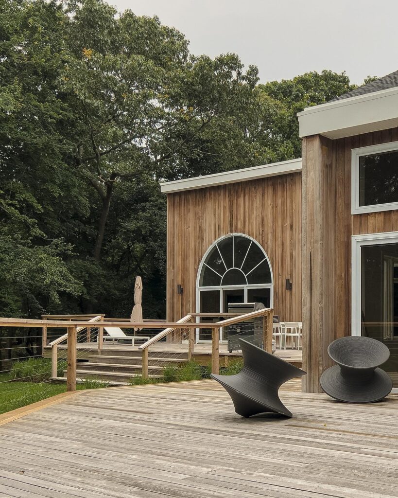 Exterior of a Wooden House with Deck and Modern Furniture Surrounded by Greenery