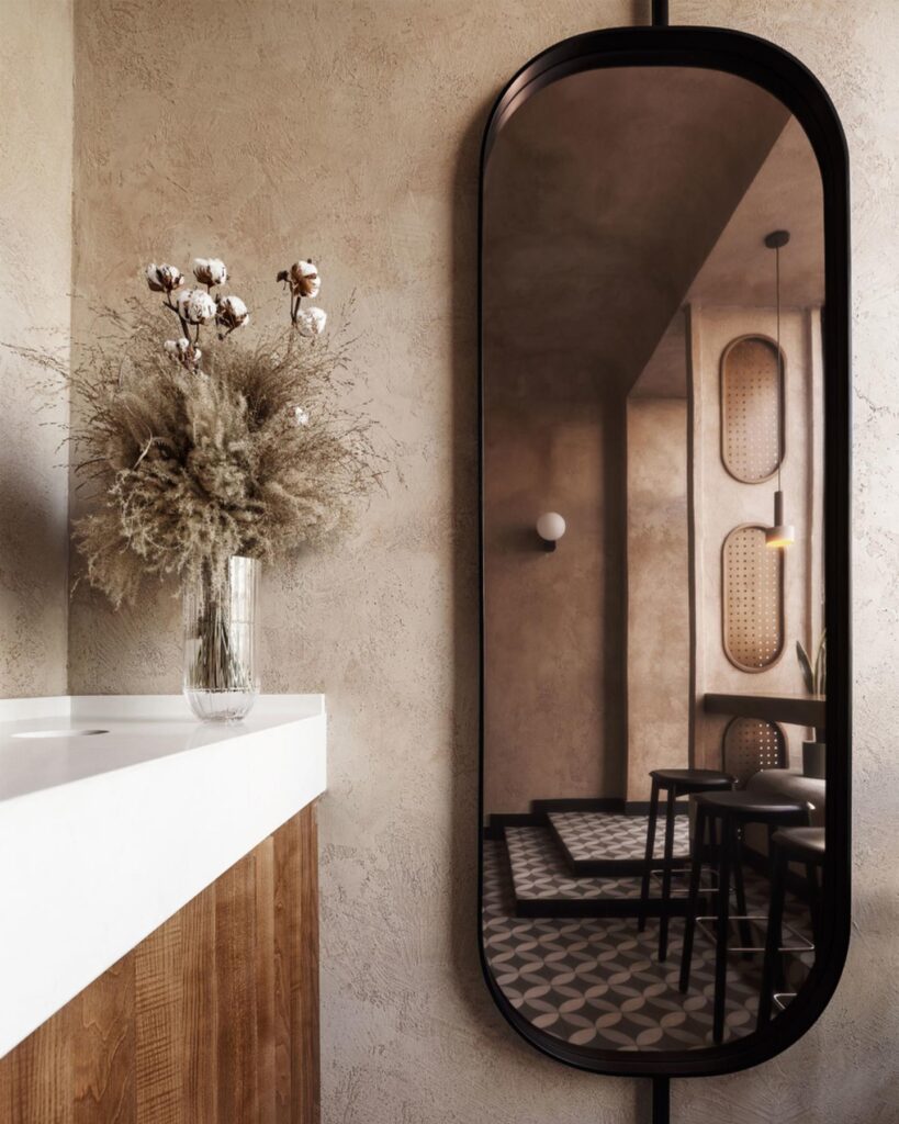 Arched Mirror Reflecting A Cozy Interior Design With Floral Decor