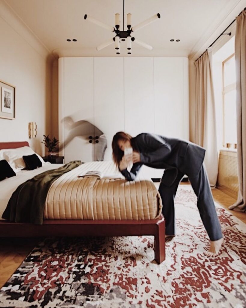 Cozy and Well-Designed Bedroom with Large Bed, Patterned Rug, and Modern Chandelier