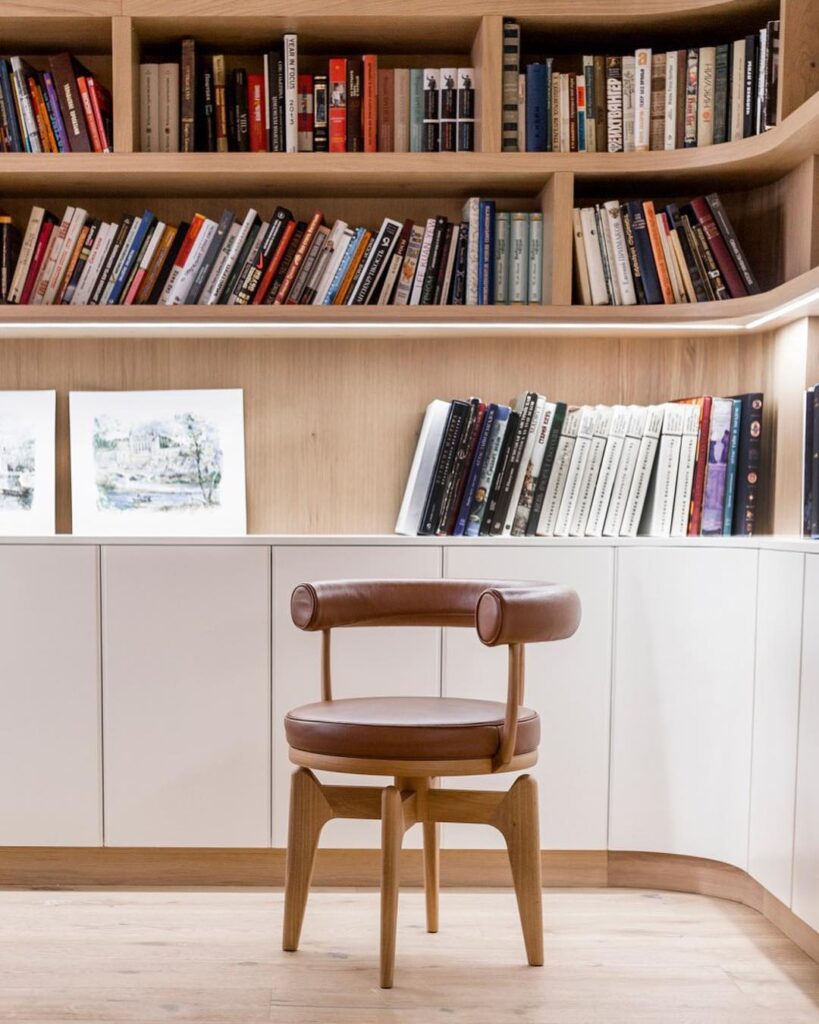 A cozy reading nook with built-in bookshelves and a leather chair.