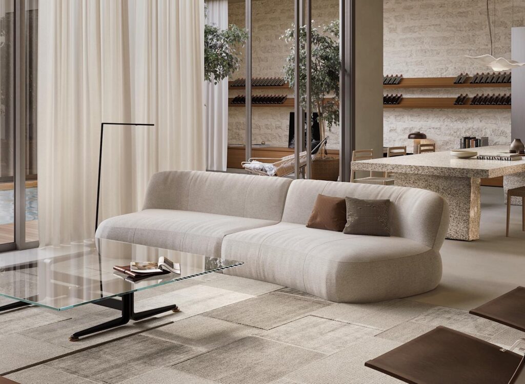 Elegant living room interior designed by Sivak+Partners. Spacious living room with large, comfortable beige sofa, glass coffee table, and minimalist floor lamp. Large windows provide natural light and views of surrounding greenery. Harmonious blend of modern and natural elements creates warm, inviting atmosphere.