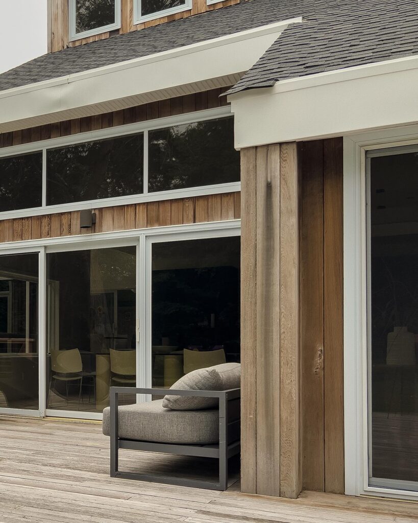 Exterior view of a modern wooden house with large windows and porch
