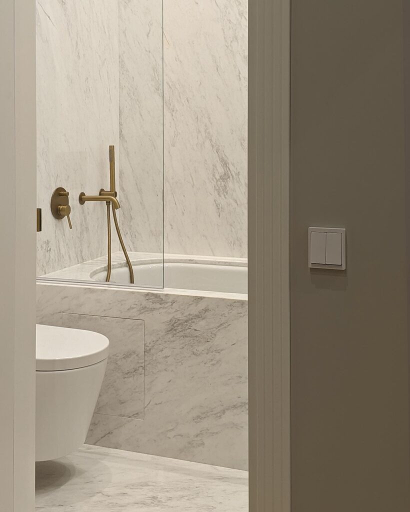 Minimalist Bathroom Design with Marble Walls and Brass Fixtures