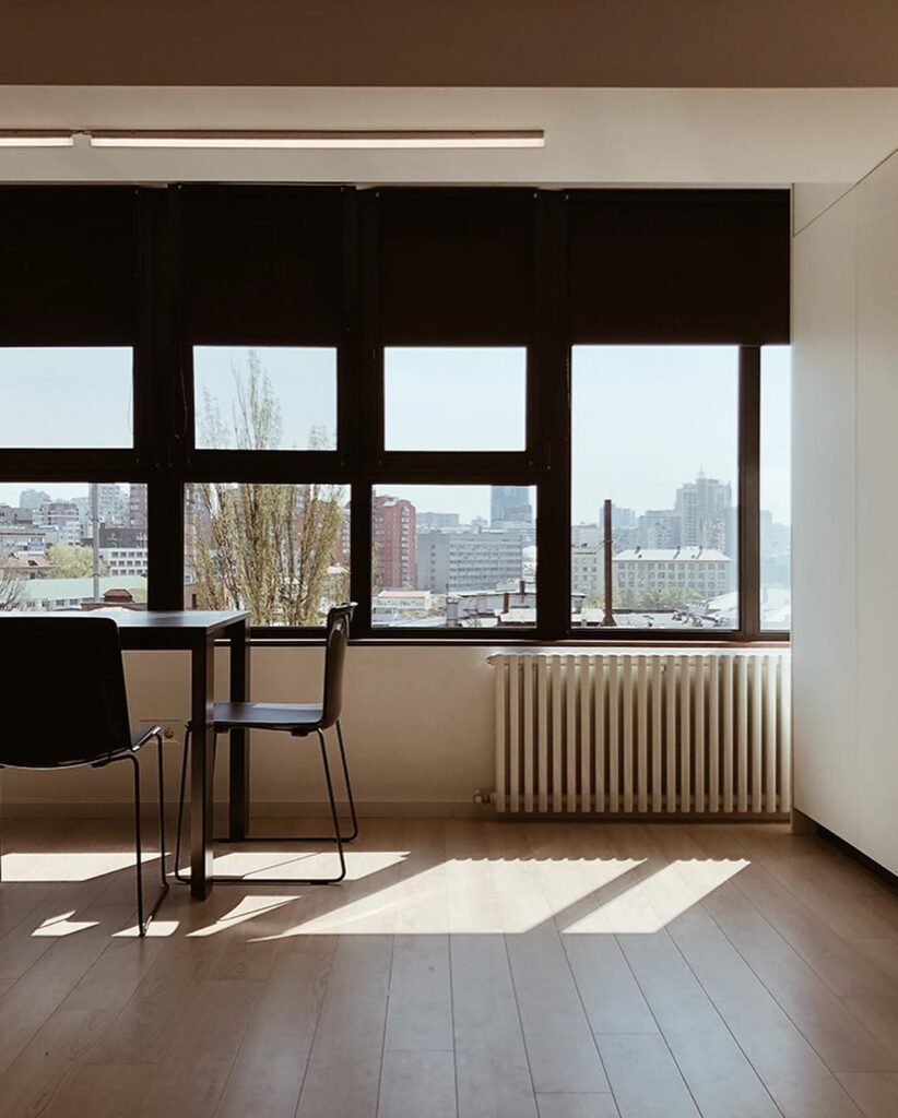 A Modern Interior With Large Windows Overlooking a City Skyline